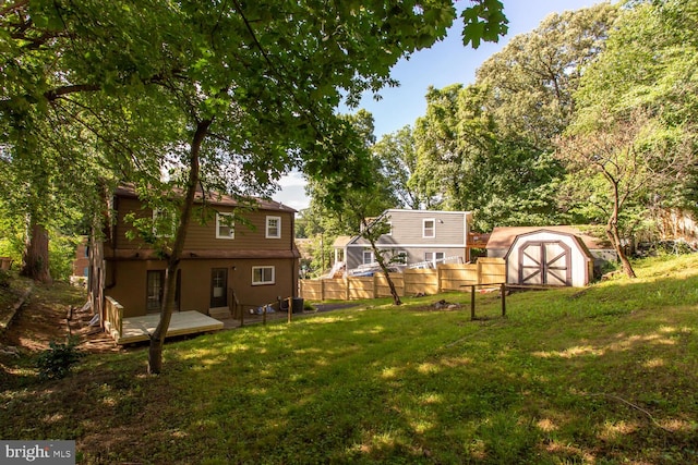 view of yard featuring a storage shed and a wooden deck