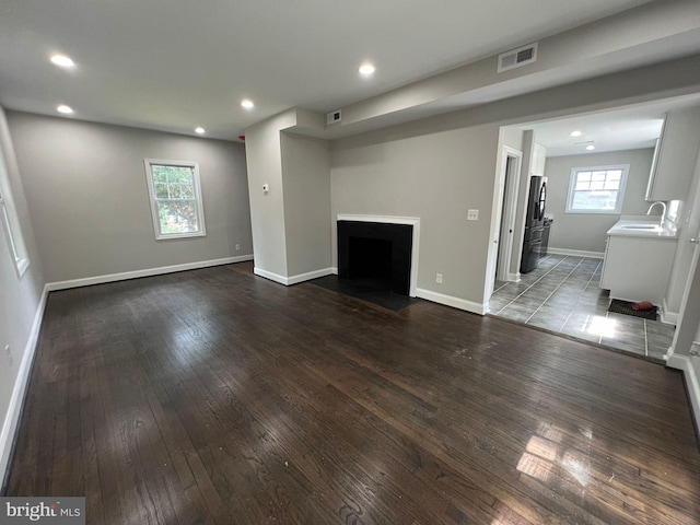 unfurnished living room featuring sink and hardwood / wood-style flooring