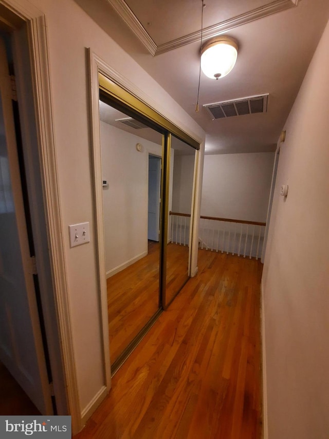 hallway featuring hardwood / wood-style floors and ornamental molding