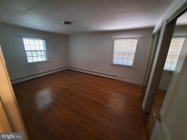 spare room featuring dark hardwood / wood-style flooring and a baseboard radiator