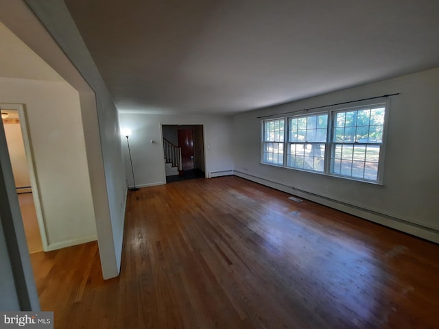 unfurnished living room featuring a baseboard radiator and hardwood / wood-style flooring