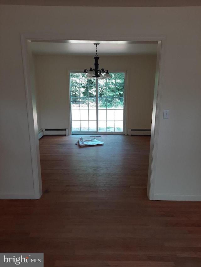 unfurnished dining area with a notable chandelier, dark hardwood / wood-style floors, and a baseboard heating unit