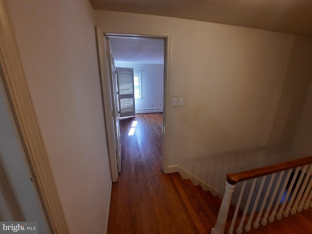 hallway featuring a baseboard heating unit and hardwood / wood-style flooring