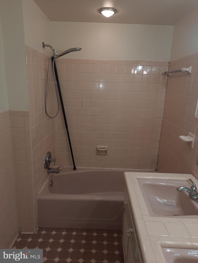 bathroom with vanity and tiled shower / bath