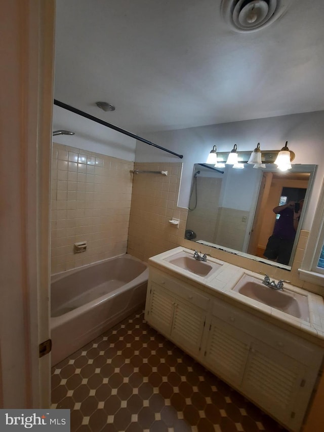 bathroom with vanity and tiled shower / bath combo