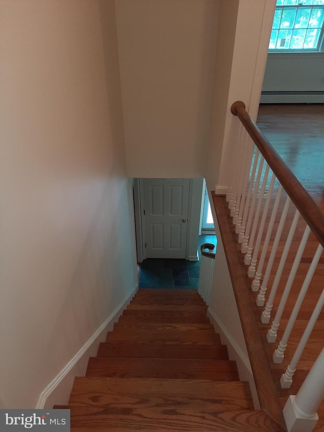 staircase with a baseboard heating unit