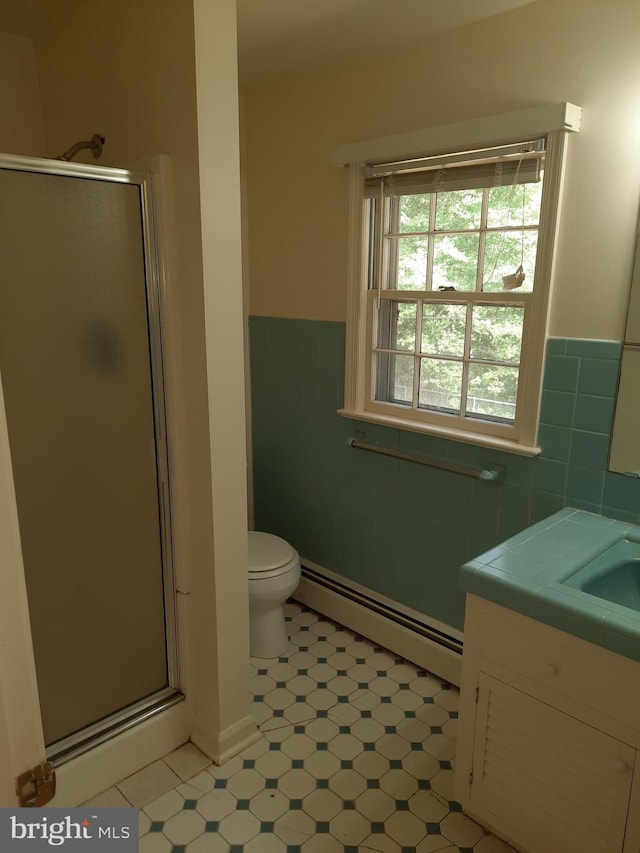 bathroom with walk in shower, vanity, tile walls, and a baseboard heating unit