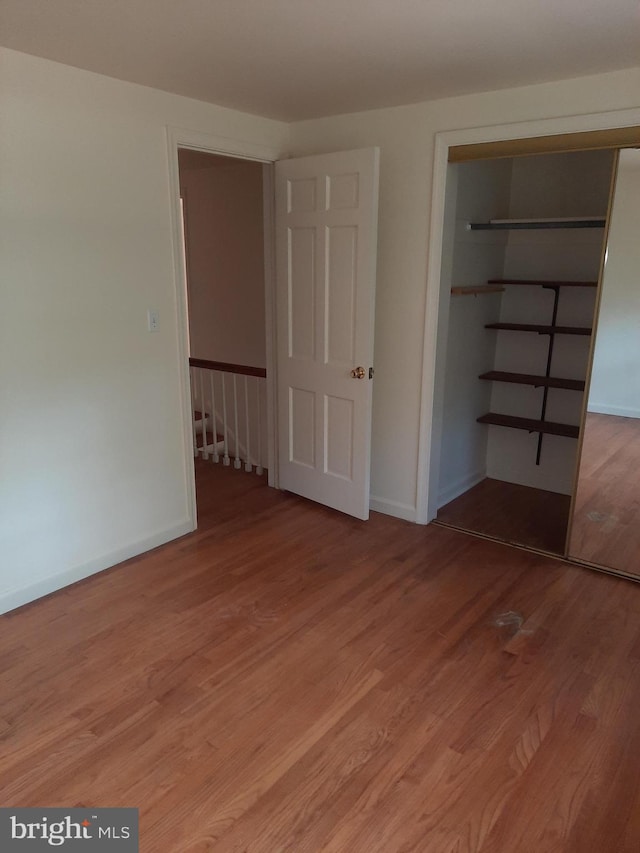 unfurnished bedroom with light hardwood / wood-style floors and a closet