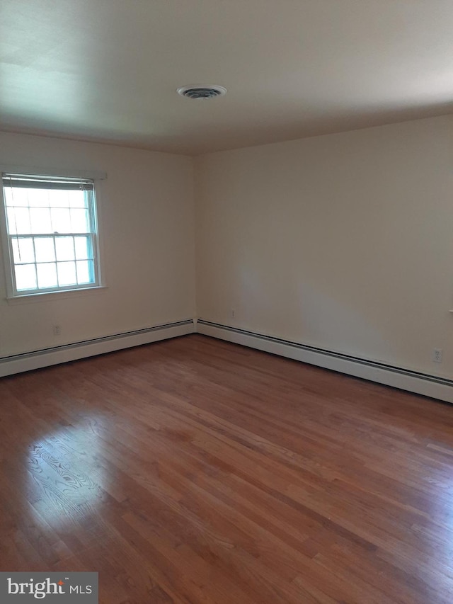 spare room with dark hardwood / wood-style flooring