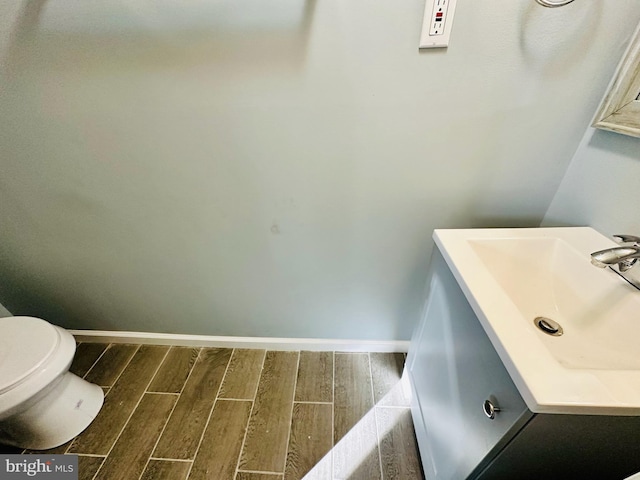 bathroom featuring hardwood / wood-style flooring, toilet, and sink