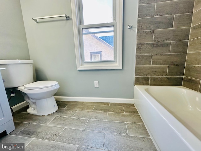 bathroom featuring tiled shower / bath combo and toilet