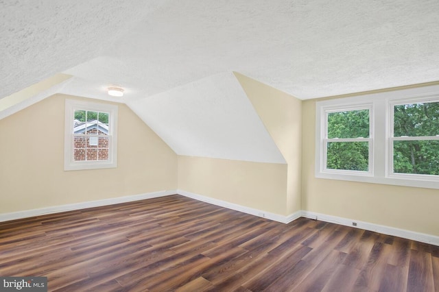 bonus room featuring lofted ceiling, dark hardwood / wood-style floors, and a textured ceiling