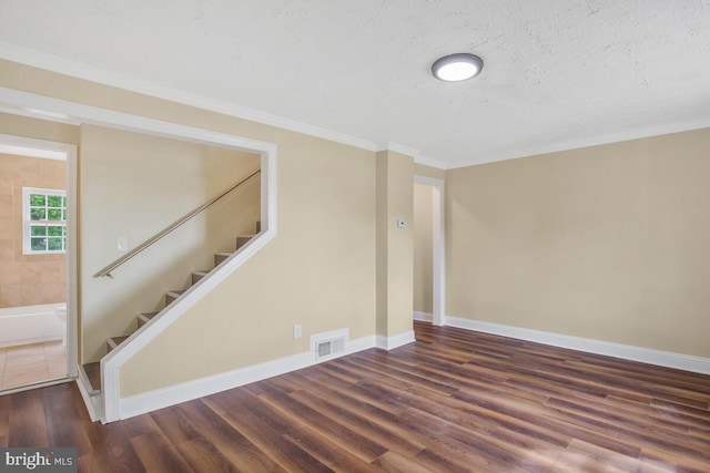 interior space with a textured ceiling, dark hardwood / wood-style flooring, and ornamental molding