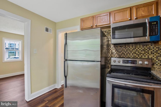 kitchen with backsplash, stainless steel appliances, and dark hardwood / wood-style floors