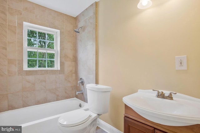 full bathroom with vanity, tiled shower / bath combo, and toilet