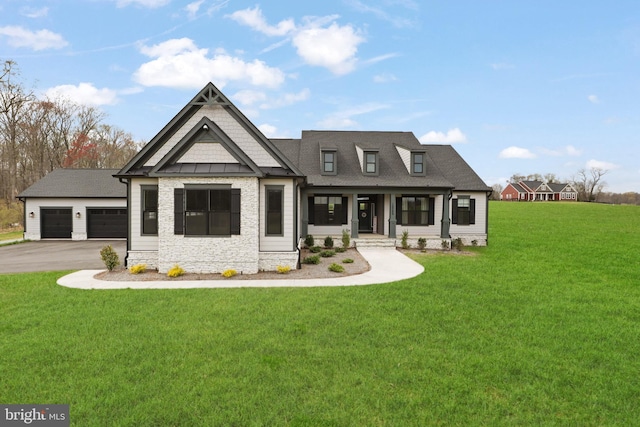 view of front facade with a front yard, a porch, and a garage