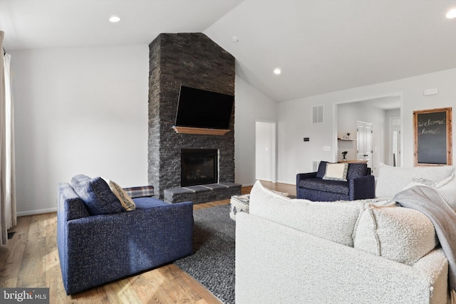 living room featuring a fireplace, wood-type flooring, and lofted ceiling