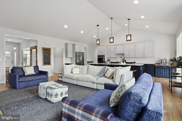 living room featuring wood-type flooring and vaulted ceiling