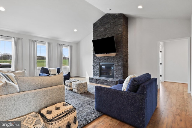 living room with hardwood / wood-style floors, a healthy amount of sunlight, and lofted ceiling