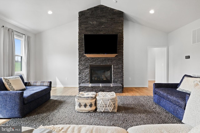 living room featuring a large fireplace, hardwood / wood-style floors, and vaulted ceiling