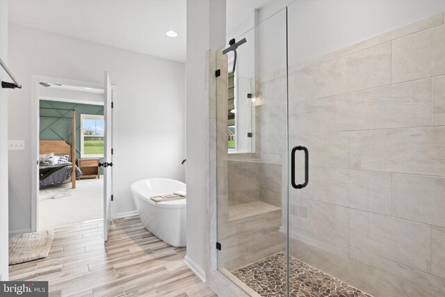 bathroom with plus walk in shower and hardwood / wood-style flooring