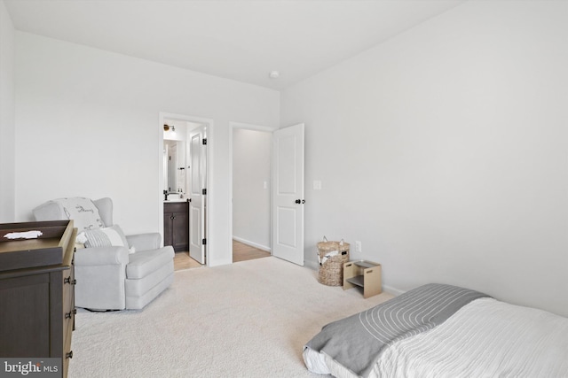 bedroom with connected bathroom and light carpet