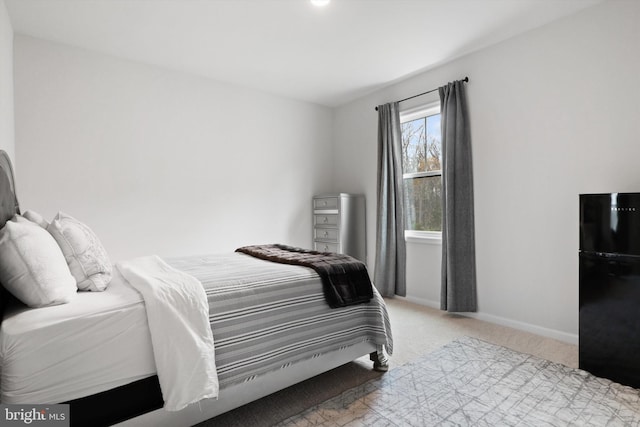 carpeted bedroom featuring black refrigerator