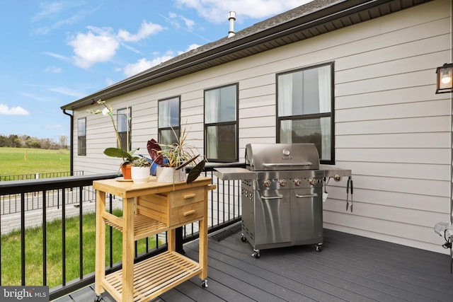 wooden deck featuring a lawn and area for grilling