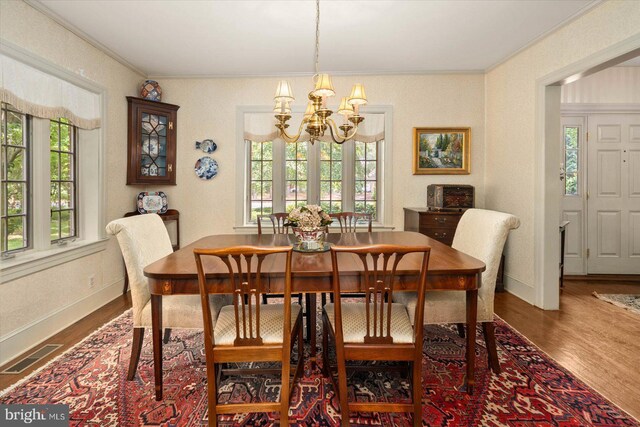 dining space with a wealth of natural light, dark hardwood / wood-style flooring, a notable chandelier, and ornamental molding