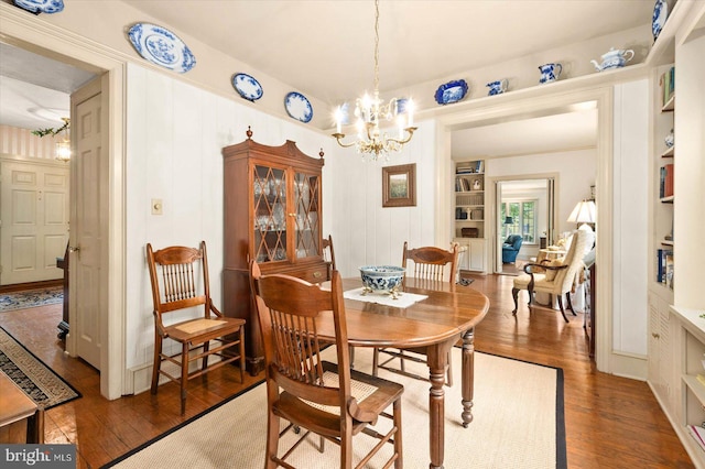 dining room featuring dark hardwood / wood-style floors and an inviting chandelier