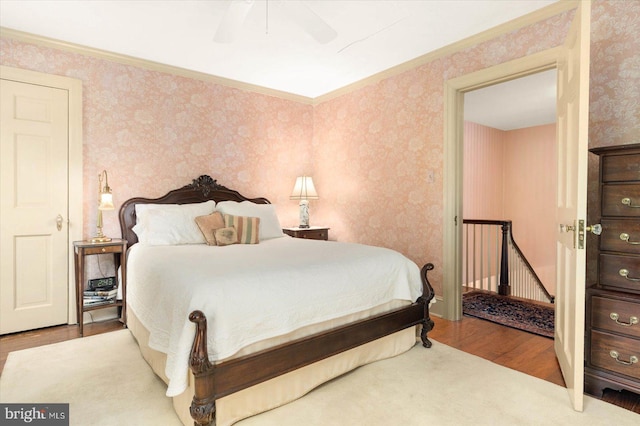 bedroom featuring hardwood / wood-style floors, ceiling fan, and ornamental molding