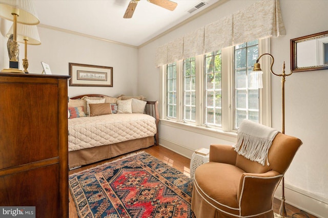 bedroom featuring crown molding, ceiling fan, wood-type flooring, and multiple windows