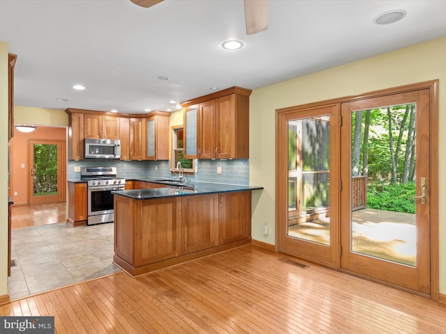 kitchen featuring kitchen peninsula, stainless steel appliances, and light wood-type flooring