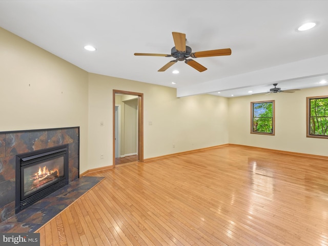 unfurnished living room with a fireplace, light wood-type flooring, and ceiling fan