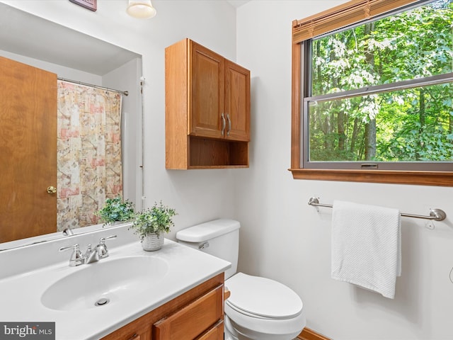 bathroom with a shower with curtain, vanity, and toilet