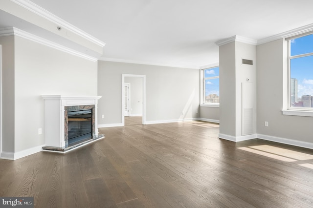 unfurnished living room featuring ornamental molding, a glass covered fireplace, baseboards, and wood finished floors