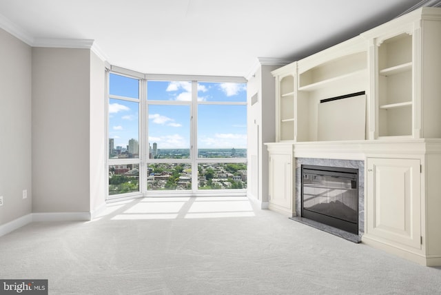 unfurnished living room featuring ornamental molding, a wall of windows, carpet, and a high end fireplace