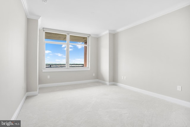 spare room featuring ornamental molding, light carpet, and baseboards