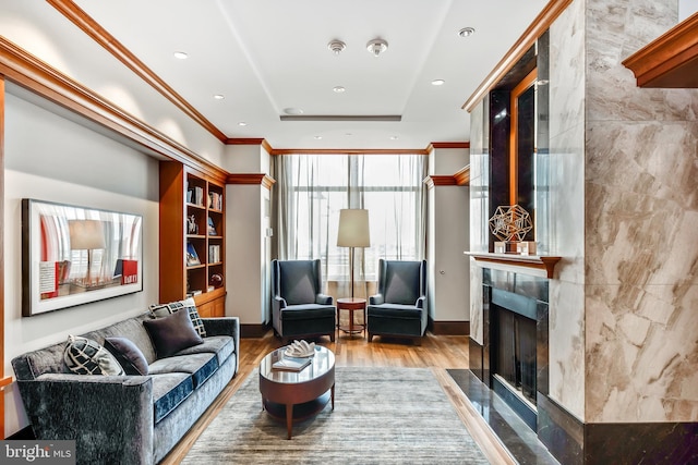 sitting room featuring a high end fireplace, wood finished floors, expansive windows, crown molding, and recessed lighting