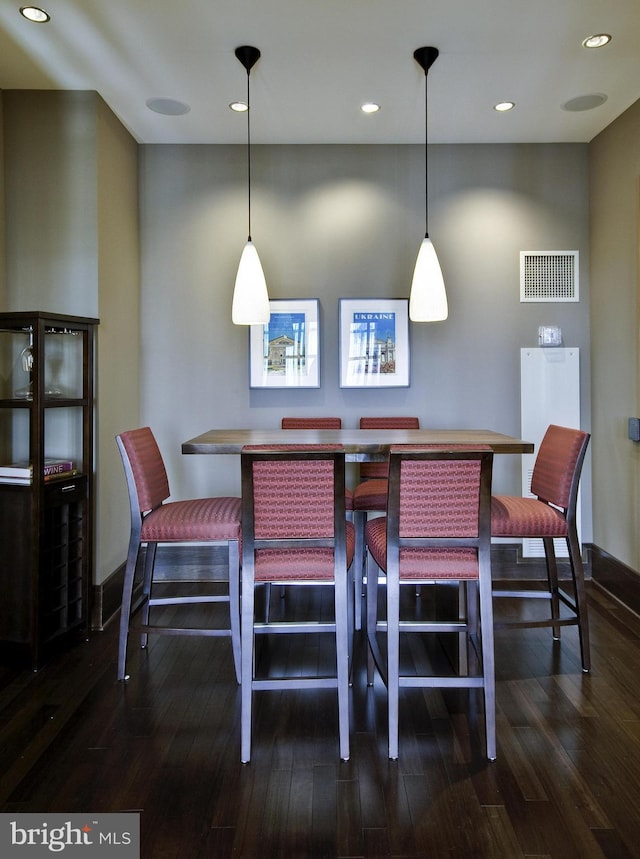 dining area with baseboards, dark wood-type flooring, visible vents, and recessed lighting