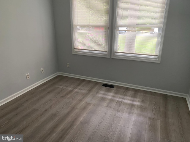 unfurnished room with dark wood-type flooring