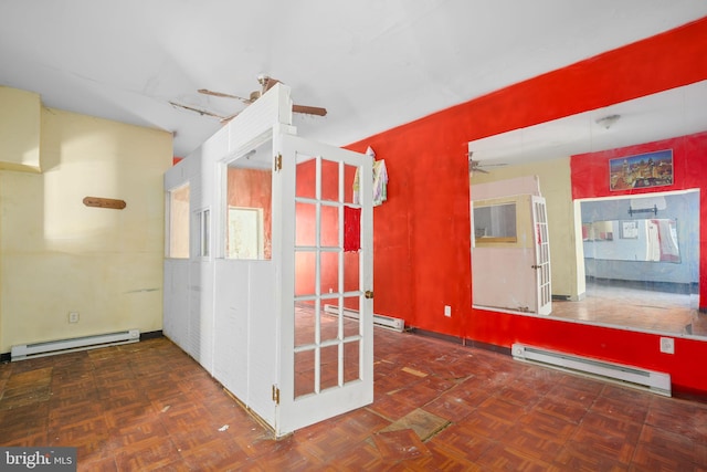 unfurnished room with dark parquet floors and a baseboard heating unit