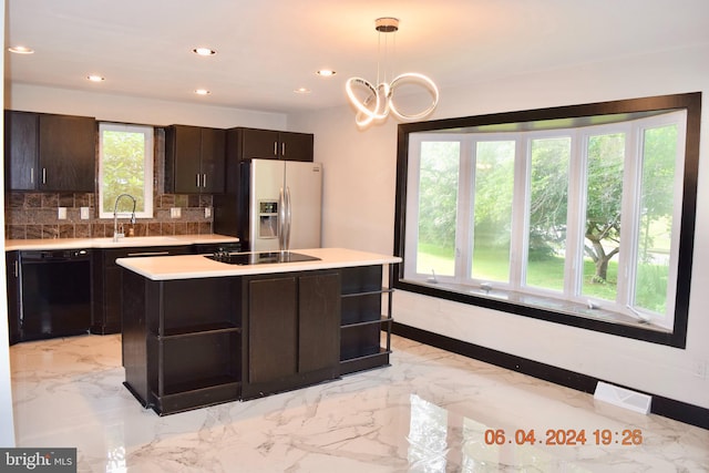 kitchen with dark brown cabinetry, sink, pendant lighting, a kitchen island, and black appliances