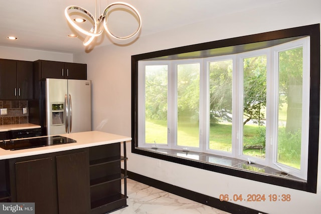 kitchen featuring an inviting chandelier, stainless steel refrigerator with ice dispenser, black electric cooktop, decorative light fixtures, and dark brown cabinets