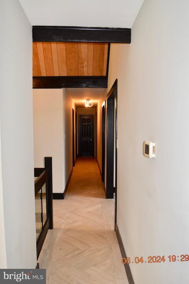 hall featuring beamed ceiling and light parquet flooring