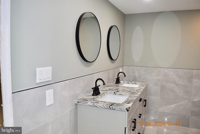 bathroom featuring vanity and tile walls