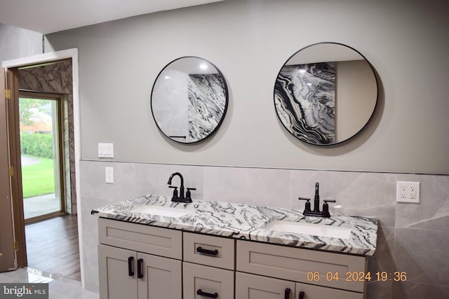 bathroom featuring wood-type flooring, vanity, and tile walls