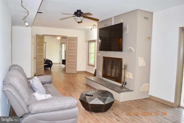 living room featuring ceiling fan and hardwood / wood-style floors