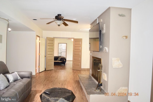 living room with ceiling fan and light hardwood / wood-style flooring