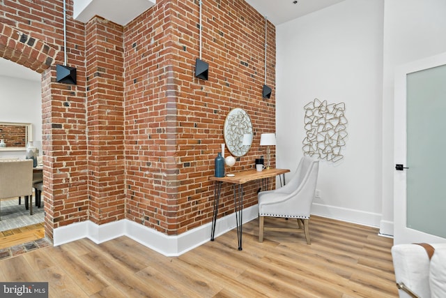 office with brick wall and hardwood / wood-style floors